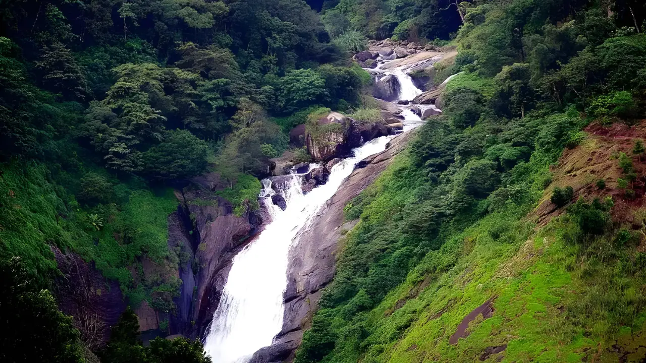 Attukad Waterfalls cascading through dense green forested hills in Munnar, Kerala