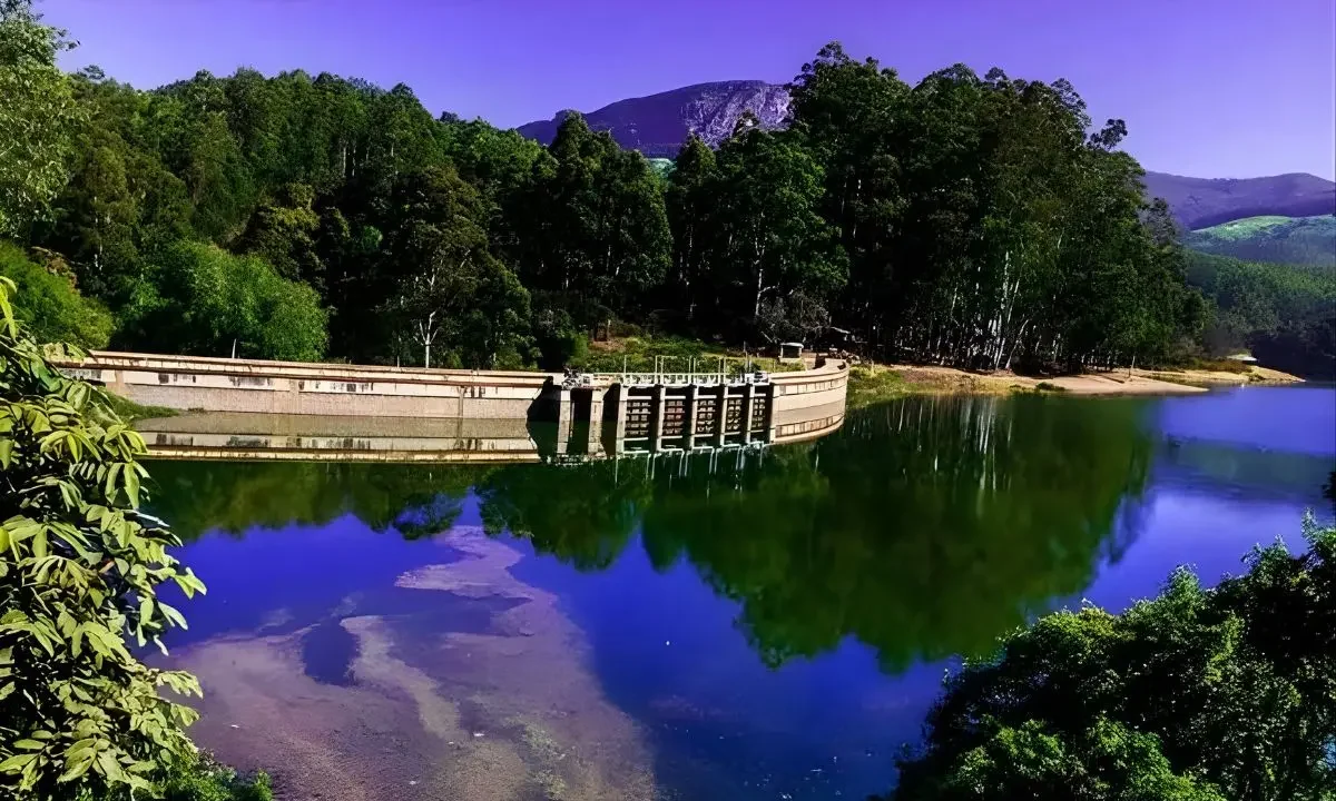 Kundala Lake surrounded by forested hills and calm waters in Munnar, Kerala