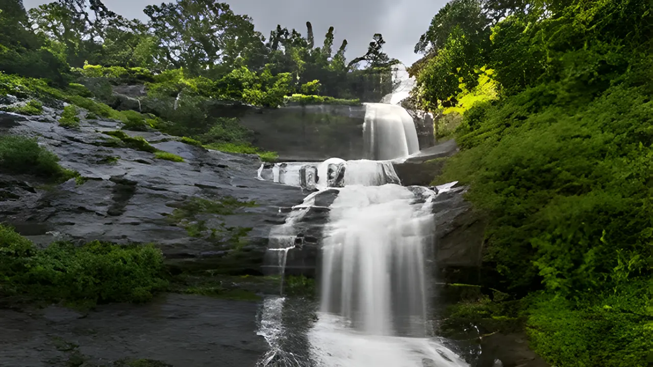 Nyayamakad Waterfalls cascading over rocky cliffs surrounded by lush greenery in Munnar, Kerala